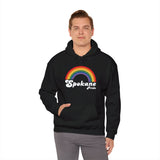 Man wearing a black Spokane Pride cozy hoodie featuring a colorful rainbow design.