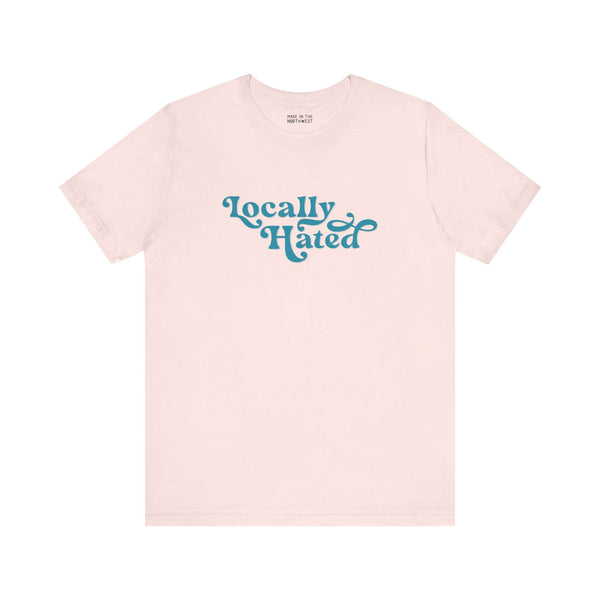 "Locally Hated Soft Tee in beige with bold cursive text, Pacific Northwest inspired, stylish statement shirt for the unapologetic."