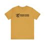 Murder Shows & Comfy Clothes T Shirt in mustard color with playful graphic and bold text.