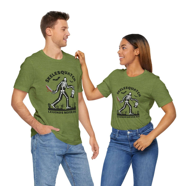 Couple wearing Skelesquatch Legends Never Die Halloween tees with skeleton sasquatch design in a graveyard setting.