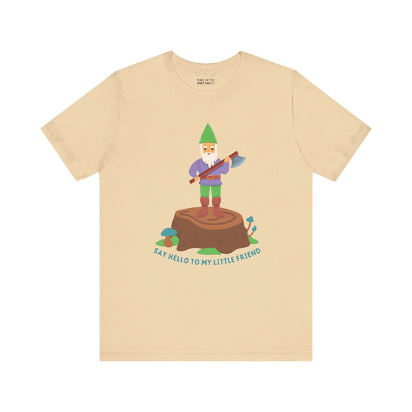 Beige tee with a gnome on a stump holding an axe; text reads 'Say Hello to My Little Friend' in playful design.