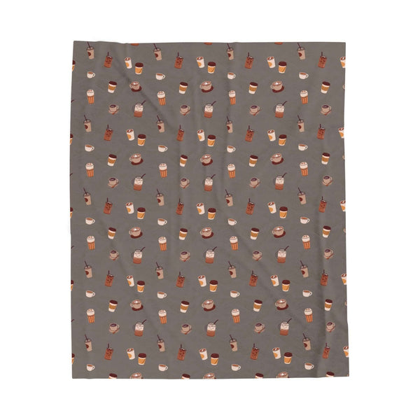The Daily Grind Coffee Lovers Lightweight Cozy Blanket featuring playful coffee designs in warm colors.