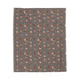 The Daily Grind Coffee Lovers Lightweight Cozy Blanket featuring playful coffee designs in warm colors.