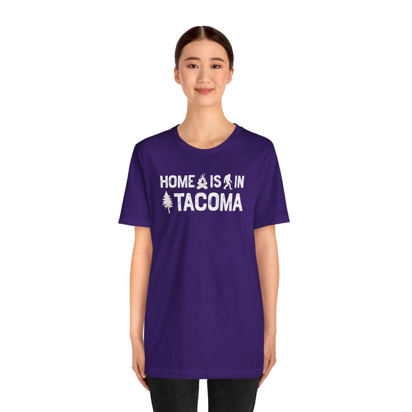 Home is in Tacoma tee worn by a model, showcasing Tacoma pride with a purple shirt design.