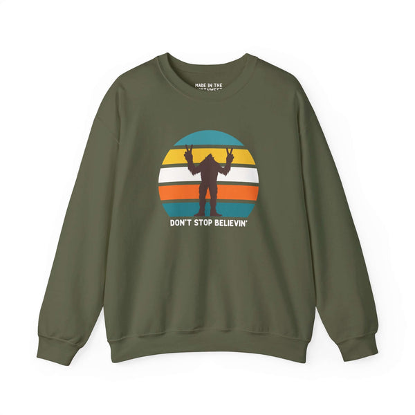 Don't Stop Believin' Bigfoot sweatshirt featuring playful sasquatch graphic and vibrant stripe design.