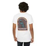 Back view of a man wearing the 'Born to Be in the Dirt' tee, featuring outdoor adventure graphics and Pacific Northwest theme.