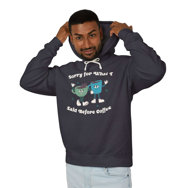 Man wearing a hoodie that says 'Sorry for What I Said Before Coffee' with playful coffee cup graphics.