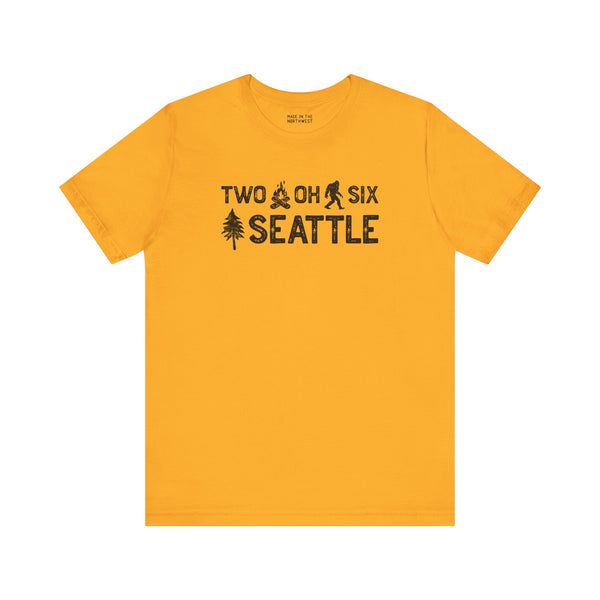 Two Oh Six Roots premium soft tee in yellow, featuring Seattle area code text with axe and tree design.