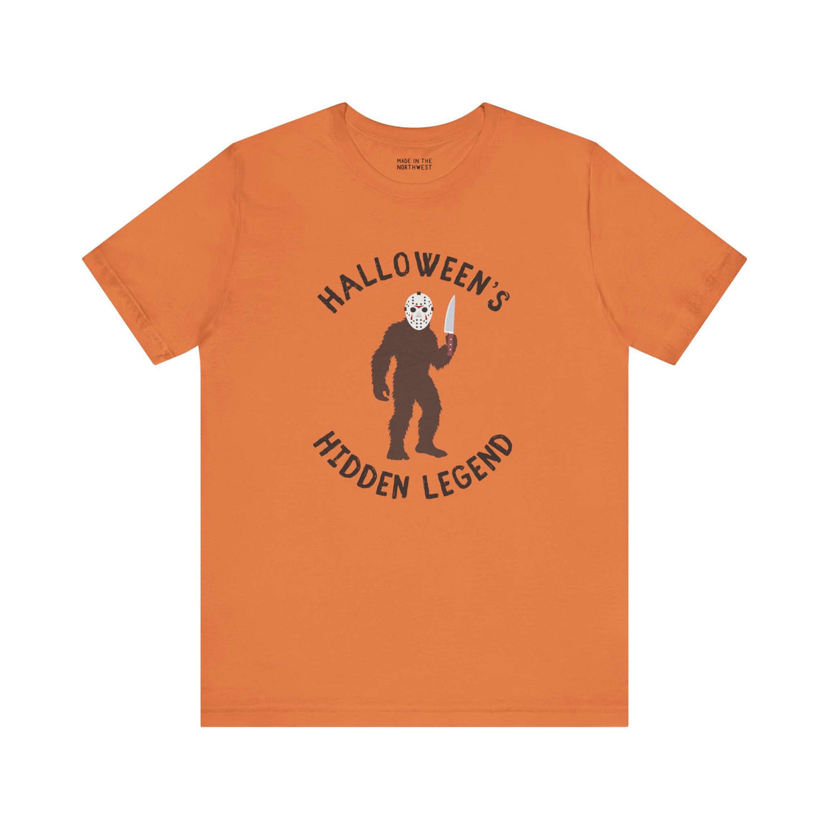 Halloween's Hidden Legend Bigfoot tee featuring Sasquatch dressed as Jason with knife on orange shirt.