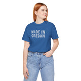 Woman wearing a blue Made in Oregon log font tee, embodying Pacific Northwest outdoor pride.