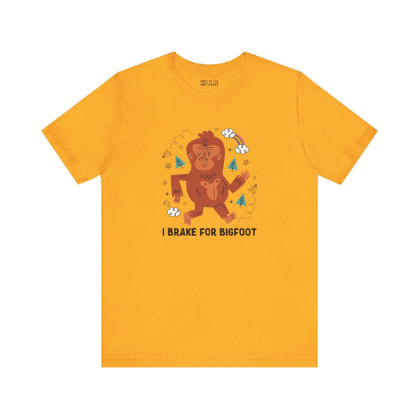 Yellow 'I Brake for Bigfoot' tee featuring a playful Sasquatch graphic, perfect for folklore enthusiasts.