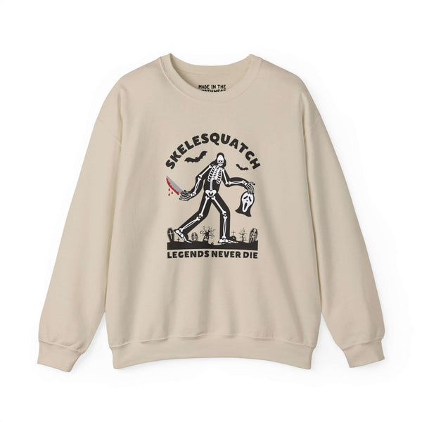 Beige sweatshirt with 'Skelesquatch: Legends Never Die' graphic featuring a skeleton Bigfoot with a bloody knife.