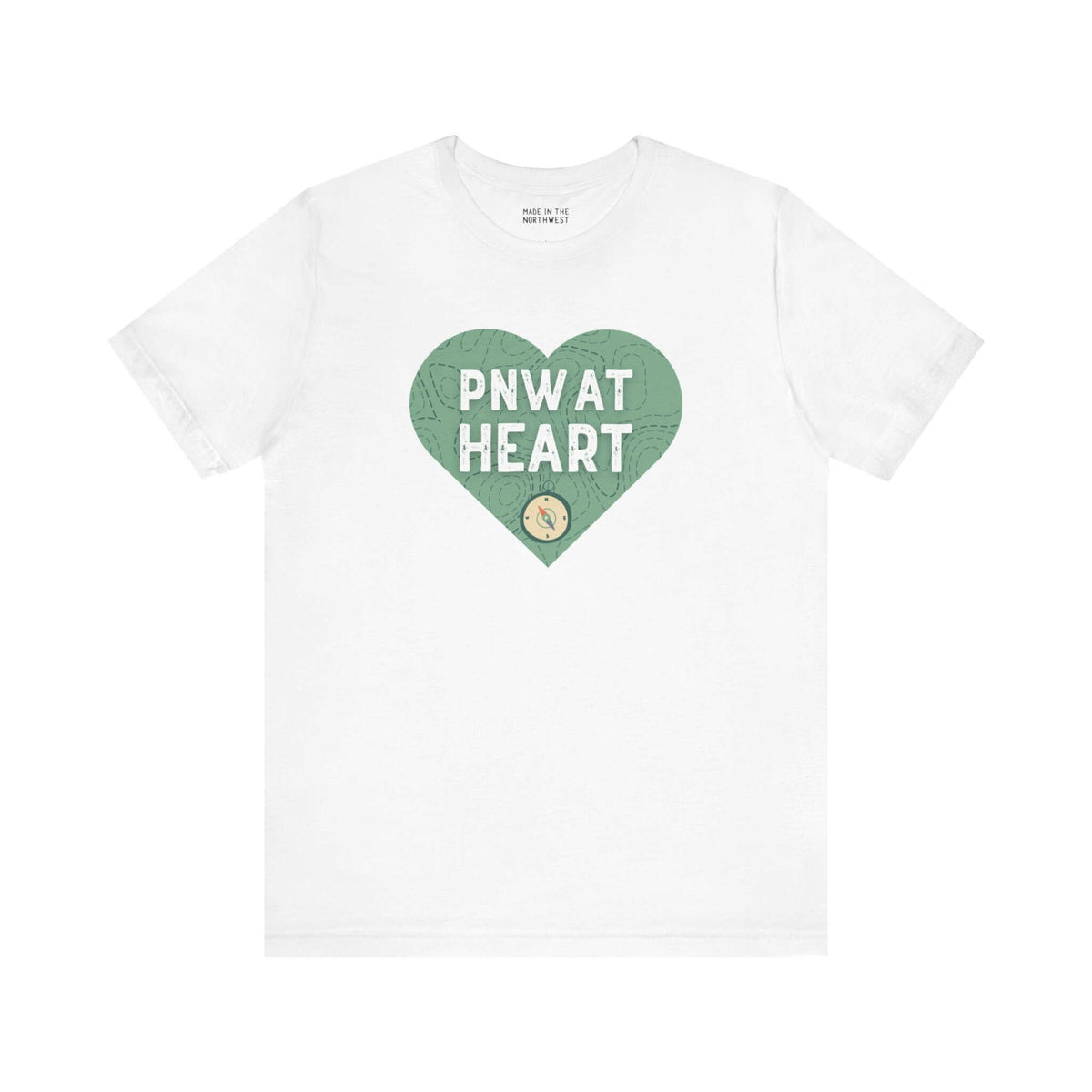 White t-shirt with green heart design featuring "PNW at Heart" text and a compass graphic, representing Pacific Northwest pride.