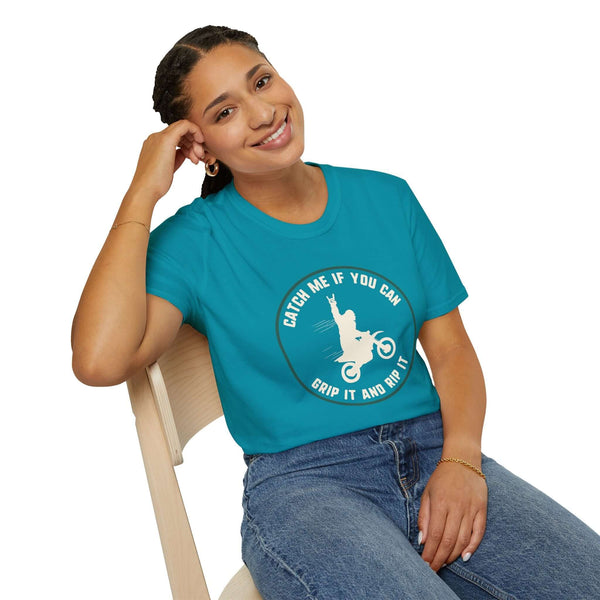 Woman wearing turquoise Catch Me If You Can Bigfoot motocross t-shirt, showcasing adventurous spirit and style.