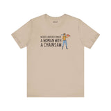 Beige premium soft tee featuring the phrase 'Never Underestimate a Woman with a Chainsaw' and an illustrated figure.