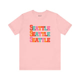 Pink Seattle Trio Soft Tee with colorful stacked block-letter design, perfect for adding a vibrant touch to your wardrobe.