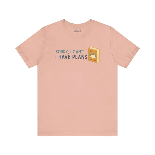 Peach soft tee with 'Sorry I Can't - I Have Plans' design, perfect for book lovers and camping enthusiasts.