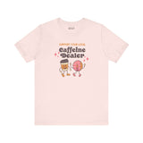 Support Your Local Caffeine Dealer coffee soft tee featuring playful coffee and donut characters on light background.