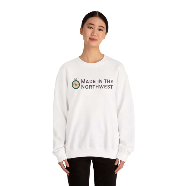 Person wearing a white sweatshirt featuring the phrase Made in the Northwest Sweatshirt with a compass graphic.