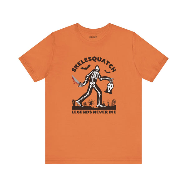 Skelesquatch Halloween premium soft tee featuring a skeleton Sasquatch with knife and mask, perfect for spooky fun.