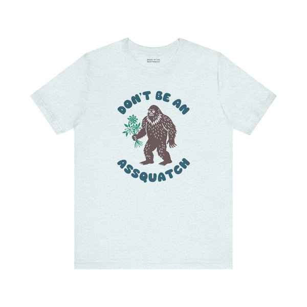 Don't Be an Assquatch Tee featuring a friendly Bigfoot holding flowers in a humorous design.