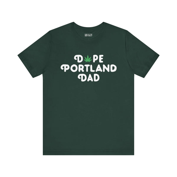 Dark green "Dope Portland Dad" tee with marijuana leaf design replacing the 'O' in 'Dope', celebrating Portland's laid-back vibe.