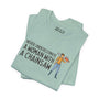 Light blue tee shirt featuring 'Never Underestimate a Woman with a Chainsaw' graphic, unisex sizing.