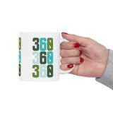 Hand holding a Three-Six-Oh Pop Vancouver ceramic mug featuring vibrant 360 design.