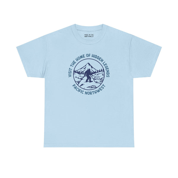 Light blue athletic tee featuring 'Visit the Home of Hidden Legends' design with mountain and Sasquatch illustration.