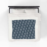 PNW Arrow Crossroads Lightweight Cozy Blanket with crossed arrows design on a bed.