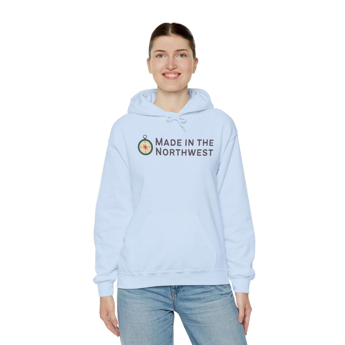 Person wearing a light blue Made in the Northwest Hoodie with a compass logo, showcasing regional pride.