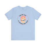 We’re All a Little Bit Gay Tee featuring a playful design on a light blue shirt.