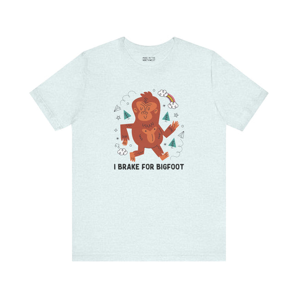 I Brake for Bigfoot graphic tee featuring a playful Sasquatch design on a light blue shirt.