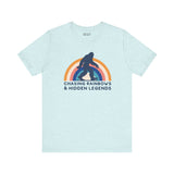 Chasing Rainbows and Hidden Legends tee featuring a vibrant Sasquatch graphic and rainbow design, perfect for PNW pride.