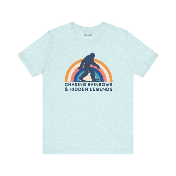 Chasing Rainbows and Hidden Legends tee featuring a vibrant Sasquatch graphic and rainbow design, perfect for PNW pride.