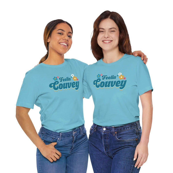 Feelin' Couvey Retro Soft Tee Embrace the vibrant spirit of Vancouver, Washington with our "Feelin' Couvey" Retro Tee! This playful design features the phrase "Feelin' Couvey" in a nostalgic 70s font, complete with colorful aqua and pink flowers. A fun tw