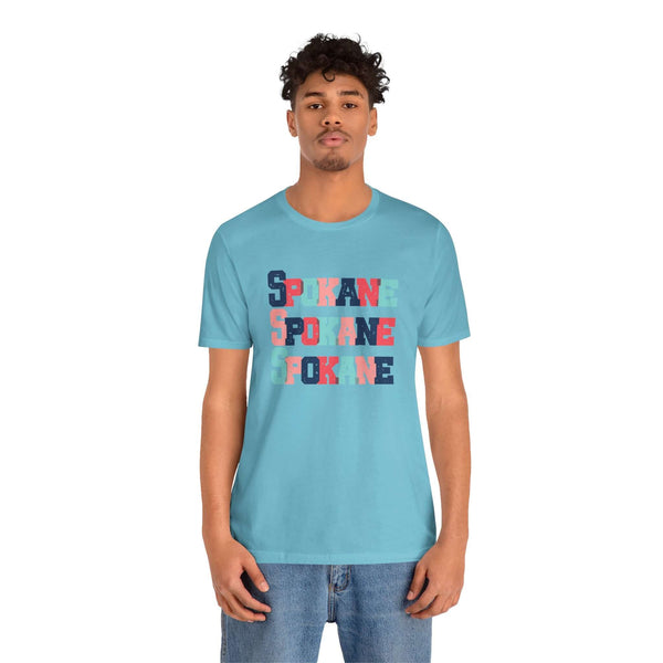 Man wearing Bold and Bright Spokane Trio Soft Tee with colorful block letters, perfect for showing love for Lilac City.