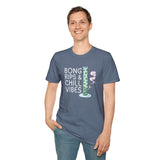 Man wearing a softstyle t-shirt with 'Bong Rips & Chill Vibes' design in relaxed setting.