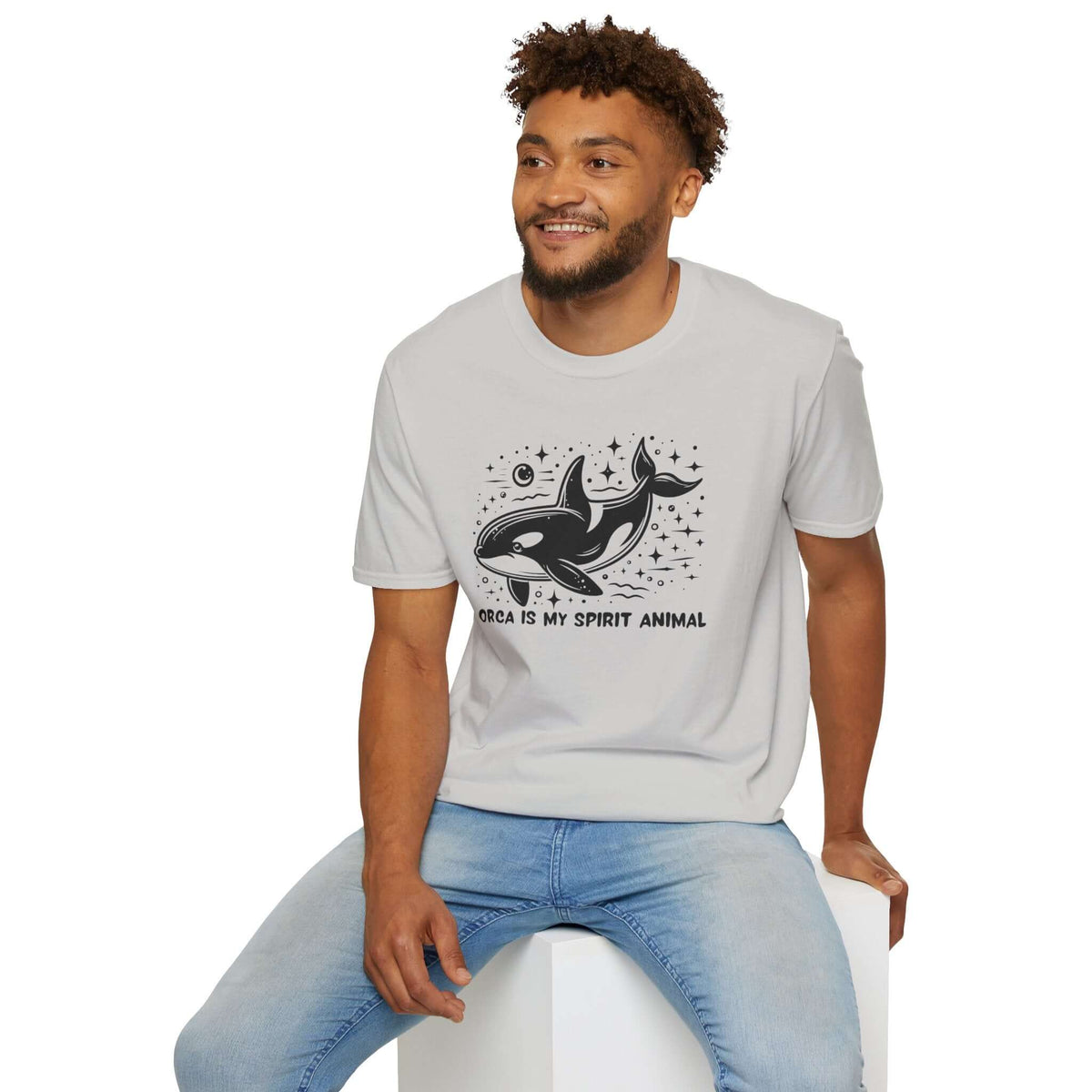Man wearing Orca Is My Spirit Animal softstyle t-shirt with a graphic design of an orca and stars.