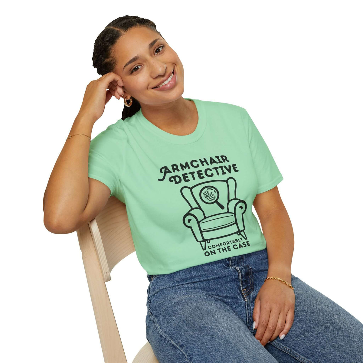 Armchair Detective T Shirt – Cozy True Crime Graphic Tee worn by a smiling model, showcasing a hand-drawn armchair and magnifying glass design.