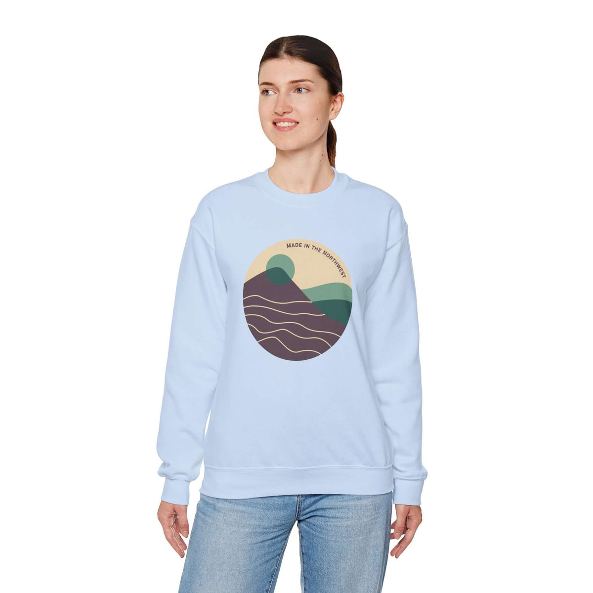 Woman wearing a Pacific Peaks Modern Circle sweatshirt with mountain design in soft colorway.