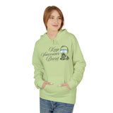 A woman wearing a light green Keep Vancouver Beard Hoodie with a bearded design, perfect for outdoor adventures.