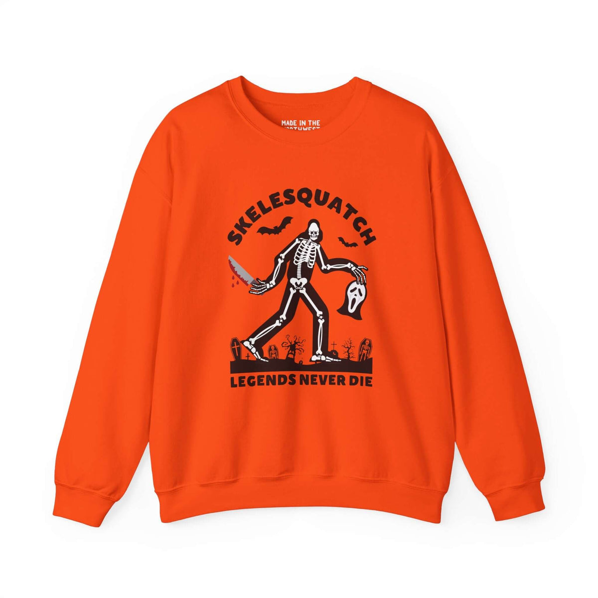 Skelesquatch Legends Never Die Halloween sweatshirt with skeleton sasquatch in graveyard, holding bloody knife and Scream mask on orange fabric.