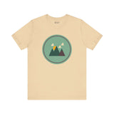 Beige minimalist forest tee with mountain design, inspired by Pacific Northwest style, featuring simple geometric shapes.