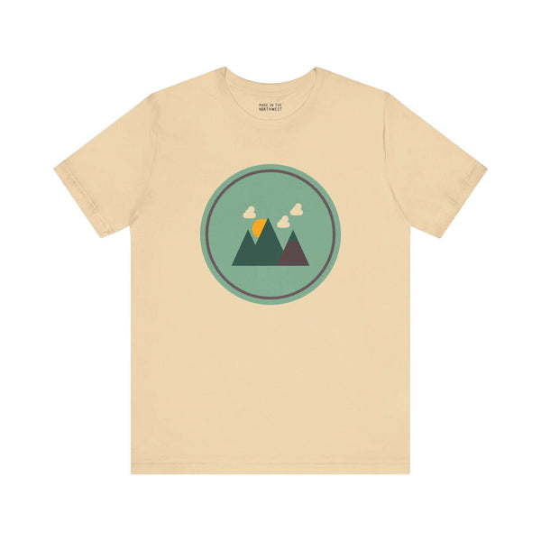 Beige minimalist forest tee with mountain design, inspired by Pacific Northwest style, featuring simple geometric shapes.