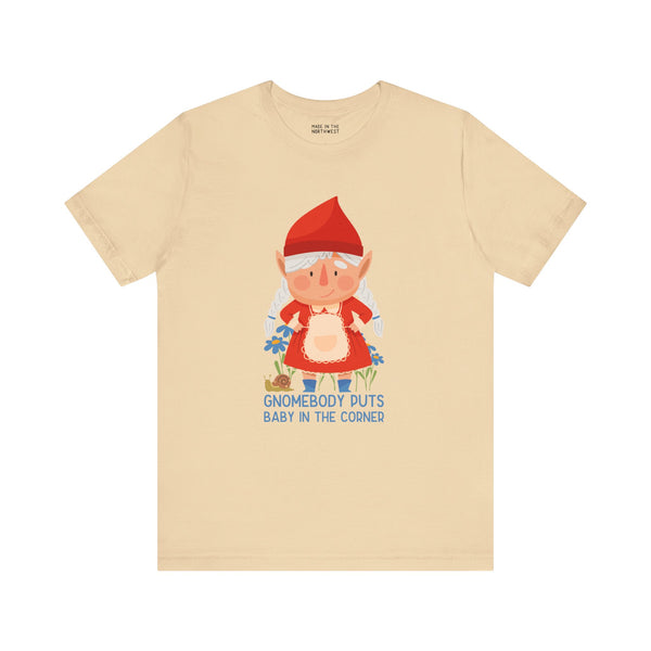 Gnomebody Puts Baby in the Corner tee featuring a whimsical gnome design on a beige shirt.