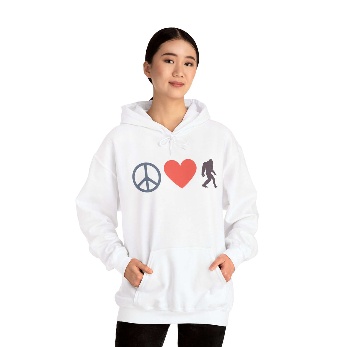 Woman wearing a Peace, Love, and Bigfoot Cozy Hoodie featuring peace symbol, heart, and Bigfoot silhouette.