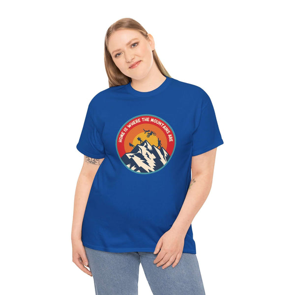 Woman wearing blue "Home is Where the Mountains Are" tee with colorful PNW design, featuring hiking, motocross, and Bigfoot.