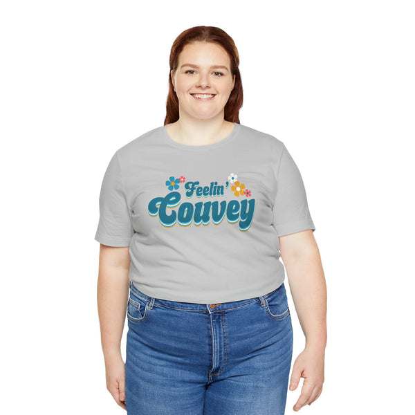 Woman modeling Feelin' Couvey retro tee with colorful flowers, celebrating Vancouver's spirit in a nostalgic 70s style.