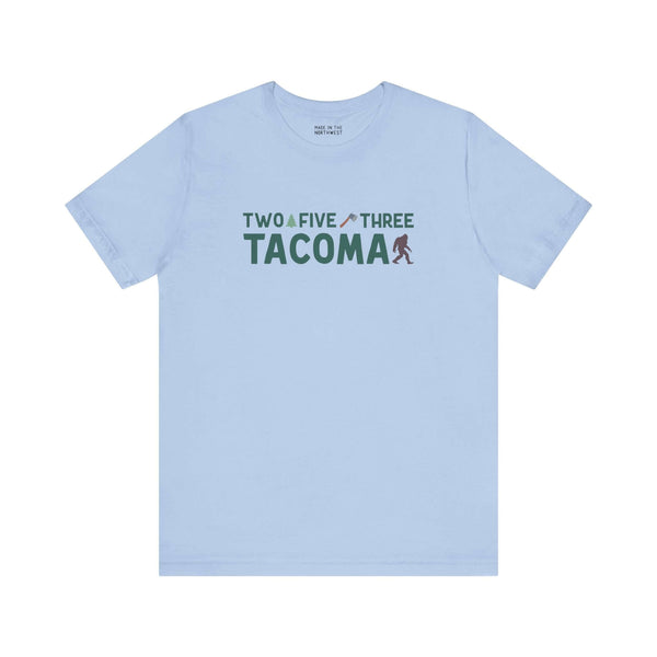 Light blue Tacoma tee with "Two Five Three" text, axe, and tree design celebrating Tacoma pride and style.